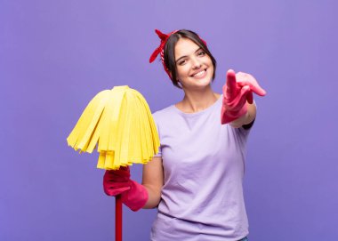 Genç ve güzel bir kadın mutlu ve kendinden emin, kamerayı iki eliyle gösteriyor ve gülüyor, seni seçiyor.