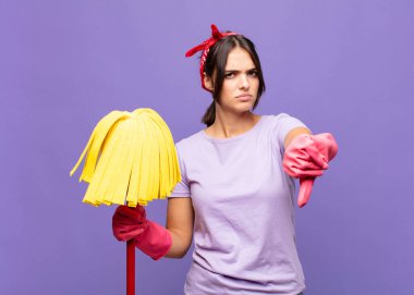 Genç, güzel bir kadın kızgın, sinirli, hayal kırıklığına uğramış ya da hoşnutsuz, ciddi bir bakışla başparmağını kaldırıyor.