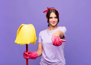 Genç, güzel bir kadın mutlu bir şekilde gülümsüyor. Dost canlısı, kendinden emin, olumlu bakışlı, bir nesne ya da konsept sunuyor ve gösteriyor.