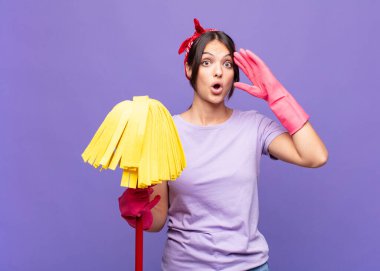 Genç ve güzel bir kadın heyecanlı ve şaşırmış görünüyor, ağzı açık, iki eli de başında, kendini şanslı bir kazanan gibi hissediyor.