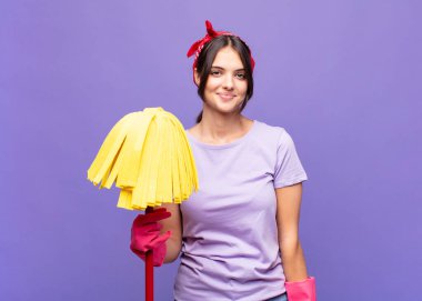 Genç ve güzel bir kadın pozitif ve kendinden emin gülümsüyor. Tatmin olmuş, arkadaş canlısı ve mutlu görünüyor.