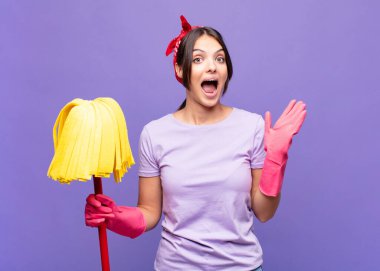 Genç, güzel bir kadın mutlu ve heyecanlı görünüyor. Beklenmedik bir sürprizle şoke olmuş. İki eli yüzü açık.