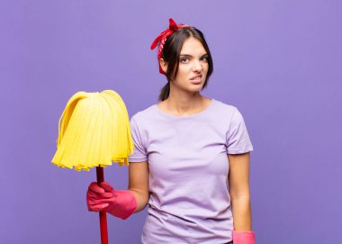 Genç, güzel bir kadın şaşkın ve şaşkın hissediyor, aptal, sersemlemiş bir ifadeyle beklenmedik bir şeye bakıyor.