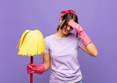 Genç ve güzel bir kadın stresli ve hayal kırıklığına uğramış hissediyor, elele tutuşuyor, yorgun, mutsuz ve migren ağrısı çekiyor.