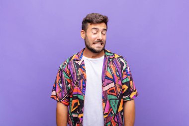 Genç adam endişeli, stresli, endişeli ve korkmuş görünüyor, panikliyor ve dişlerini sıkıyor.