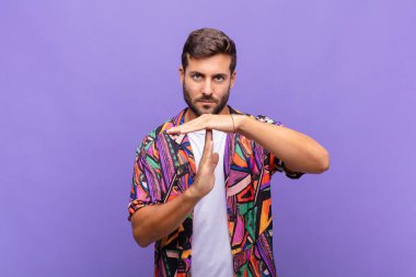 Genç adam ciddi, sert, kızgın ve hoşnutsuz görünüyor.