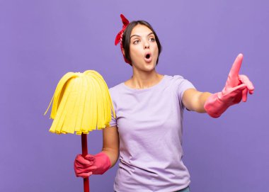 Genç, güzel bir kadın şaşkın ve şaşırmış hissediyor. Şaşırmış ve ağzı açık bir şekilde hayranlıkla yukarı bakıyor.