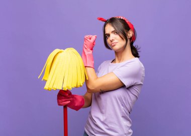Genç, güzel bir kadın kendini mutlu, tatmin olmuş ve güçlü hissediyor, kaslı ve formda, spor salonundan sonra güçlü görünüyor.
