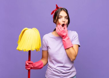 Ağzı ve gözleri açık, eli çenesinde genç ve güzel bir kadın. Hoş olmayan bir şok geçiriyor.