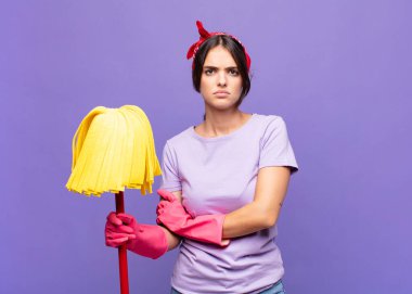 Genç, güzel bir kadın hayal kırıklığına uğramış, hayal kırıklığına uğramış, ciddi görünüyor, kızgın ve kollarını kavuşturmuş.