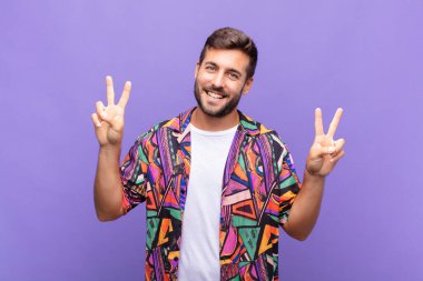 Genç adam gülümsüyor ve mutlu görünüyor, arkadaş canlısı ve tatmin olmuş, zafer ya da barış simgesi.