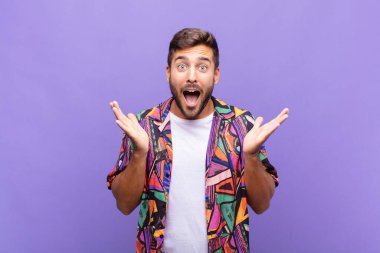 Genç adam mutlu, heyecanlı, şaşırmış ya da şaşırmış hissediyor. İnanılmaz bir şeye gülümsüyor ve şaşırıyor.