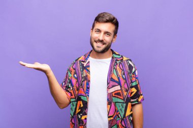 Genç adam gülümsüyor, kendinden emin, başarılı ve mutlu, fotokopi alanında fikir veya konsept gösteriyor.