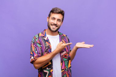 Genç adam gülümsüyor, mutlu, kaygısız ve memnun, fotokopi alanındaki konsepte ya da fikre işaret ediyor.