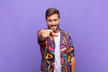 Genç adam kameraya tatmin olmuş, kendinden emin, dostane bir gülümsemeyle bakıyor ve seni seçiyor.