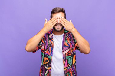 Genç adam gülümsüyor ve mutlu hissediyor, iki eliyle gözlerini kapatıyor ve inanılmaz bir sürpriz bekliyor.