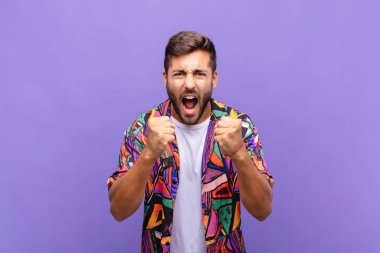 Delikanlı sinirli sinirli, sinirli bakışlar ve yumruklarla bağırıyor. Öfkeli hissediyor.