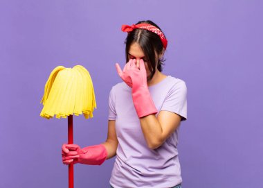 Genç ve güzel bir kadın stresli, mutsuz ve hayal kırıklığına uğramış, alnına dokunuyor ve şiddetli baş ağrısı çekiyor.