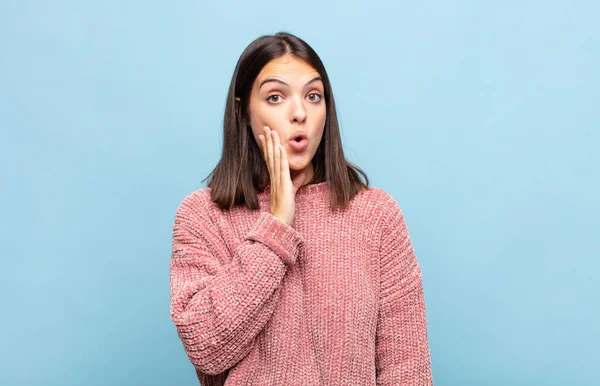 Genç, güzel bir kadın, ağzı açık bir şekilde yüz yüze inanmayarak şok olmuş ve hayrete düşmüş hissediyor.