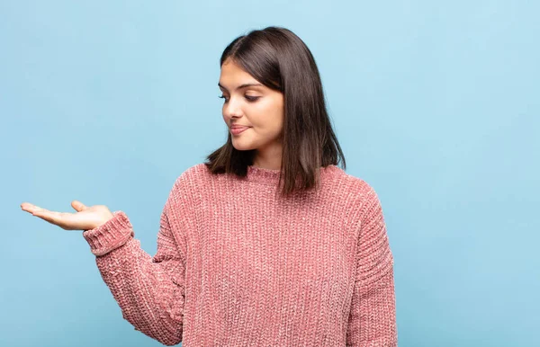 Genç, güzel bir kadın kendini mutlu hissediyor ve gülümsüyor. Yan taraftaki bir nesneye ya da konsepte bakıyor.