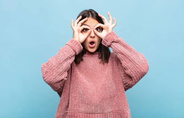 Genç, güzel bir kadın şaşkın, şaşırmış ve şaşırmış hissediyor. Elinde şaşkın, inançsız bir bakışla gözlük tutuyor.