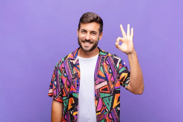 Genç adam mutlu, rahat ve tatmin olmuş hissediyor. Onayını iyi bir hareketle gösteriyor. Gülümsüyor.