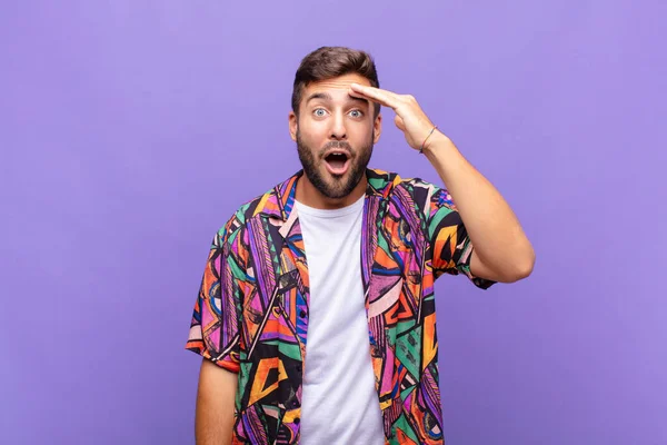 Genç adam mutlu, şaşkın ve şaşırmış görünüyor, gülümsüyor ve inanılmaz ve inanılmaz iyi haberleri fark ediyor.