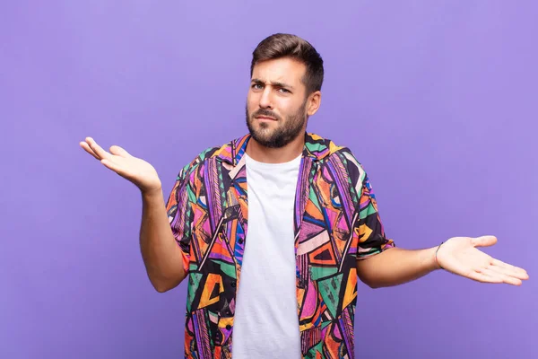 Genç adam şaşkın, şaşkın ve stresli görünüyor, farklı seçenekler arasında merak ediyor, kararsız hissediyor.