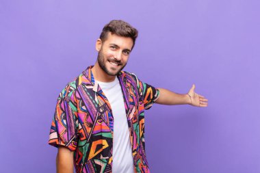 Genç adam kendini mutlu ve neşeli hissediyor, gülümsüyor ve seni hoş karşılıyor, seni dostça bir jestle içeri davet ediyor.