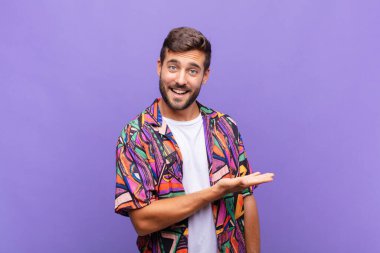 Genç adam neşeyle gülümsüyor, mutlu hissediyor ve bir konsepti fotokopi uzayında el ele vererek gösteriyor.