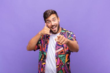 Genç adam neşeyle gülümsüyor ve kamerayı işaret ediyor. Sonra seni arıyor, telefonla konuşuyor.