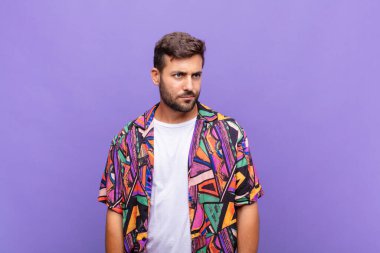 Genç adam üzgün, üzgün ya da kızgın ve olumsuz bir tavırla, anlaşmazlık içinde somurtuyor.