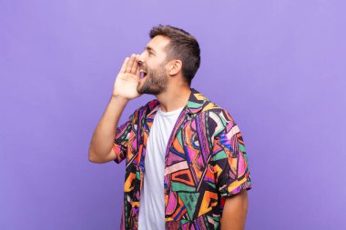 Genç adam profil görüntüsü, mutlu ve heyecanlı görünüyor, bağırıyor ve kenardaki boşluğu kopyalamak için arıyor