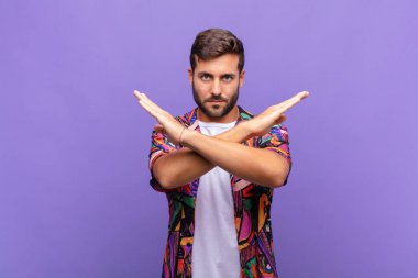 Genç adam senin bu tavırlarından rahatsız ve bıkkın görünüyor, yeter artık! Eller önde çapraz, durmanı söylüyor.