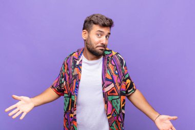 young man feeling clueless and confused, having no idea, absolutely puzzled with a dumb or foolish look