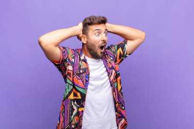 Dehşete düşmüş ve şok olmuş gibi görünen ağzı açık genç bir adam korkunç bir hata yüzünden, el ele tutuşuyor.