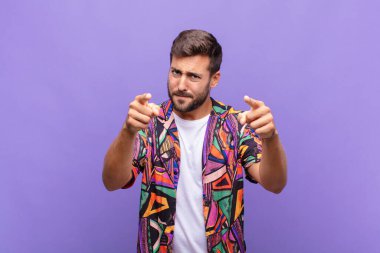 Genç adam kameraya hem parmaklarıyla hem de kızgın bir ifadeyle sana görevini yapmanı söylüyor.