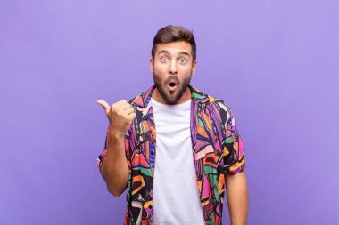 Genç adam inançsızlıktan şaşkın şaşkın bakıyor, yan taraftaki objeyi işaret ediyor ve diyor ki: