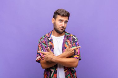 Genç adam şaşkın ve şaşkın görünüyor, güvensiz ve şüpheyle zıt yönleri işaret ediyor.