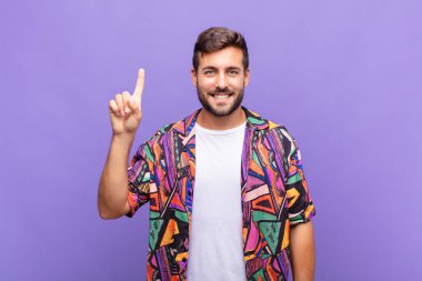 Genç adam mutlu ve mutlu bir şekilde gülümsüyor, tek eliyle boşluğu dolduruyor.