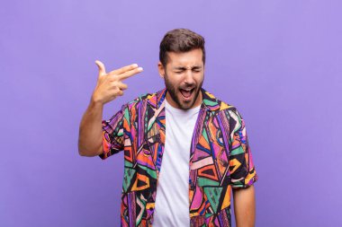 Genç adam mutsuz ve stresli görünüyor, intihar jesti elle silah işareti yapıyor, kafasını işaret ediyor.