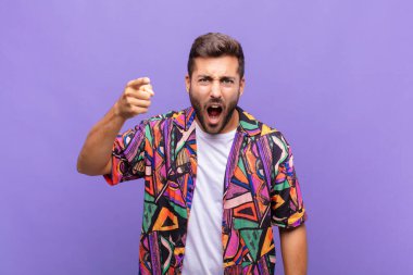 Öfkeli agresif bir ifadeyle kameraya bakan genç bir adam öfkeli, çılgın bir patron gibi görünüyor.