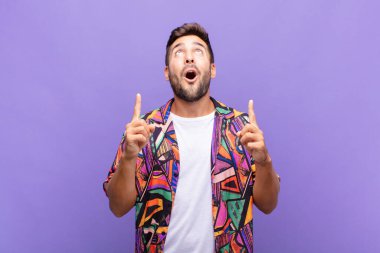 Delikanlı korkuyla ve ağzı açık bir şekilde şaşkın ve şaşkın bir bakışla yukarıya bakıyor.