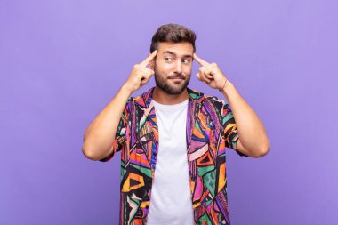 Genç adam odaklanmış ve bir fikir üzerinde kafa yoruyor, bir meydan okumaya veya soruna bir çözüm hayal ediyor.