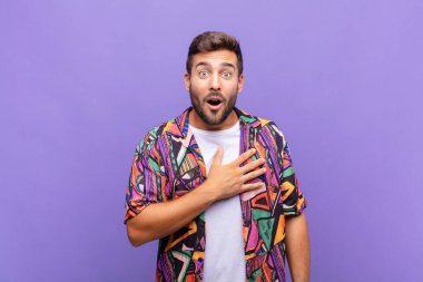 Genç adam şok olmuş ve şaşırmış hissediyor, gülümsüyor, el ele tutuşuyor, o olmaktan ya da minnettarlık göstermekten mutlu.