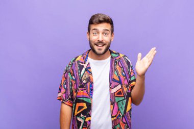 Genç adam mutlu, şaşırmış ve neşeli hissediyor, pozitif bir tavırla gülümsüyor, bir çözüm ya da fikir buluyor.