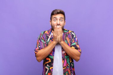 Genç adam endişeli, üzgün ve korkmuş hissediyor, elleriyle ağzını kapatıyor, endişeli ve berbat görünüyor.