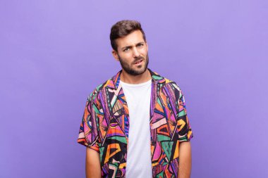 young man feeling puzzled and confused, with a dumb, stunned expression looking at something unexpected