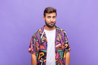 Genç adam kendini şaşkın ve şüpheli hissediyor, merak ediyor ya da karar vermeye çalışıyor.