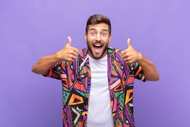 Genç adam gülümsüyor. Mutlu, pozitif, kendinden emin ve başarılı görünüyor.